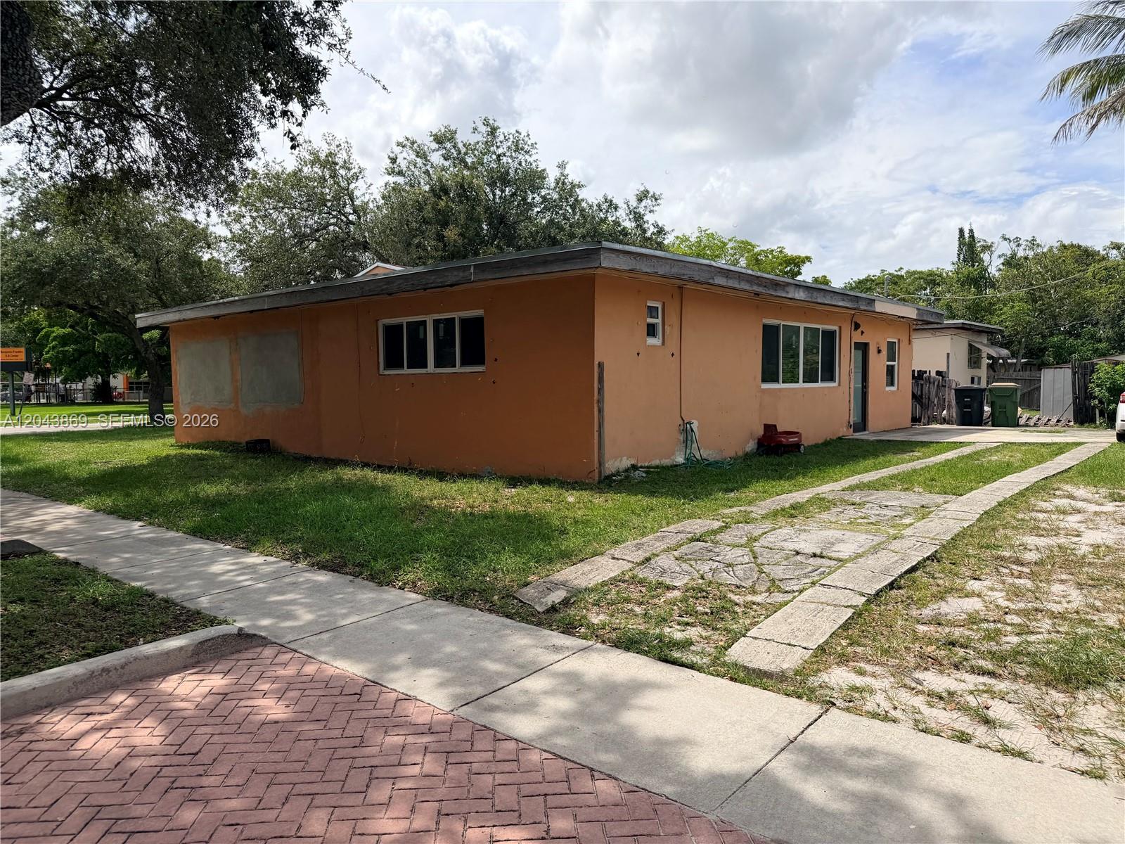 A single-story orange house with a flat roof and a stone driveway — 13105 NW 12th Ave, North Miami FL 33168, NORTH MIAMI, FL