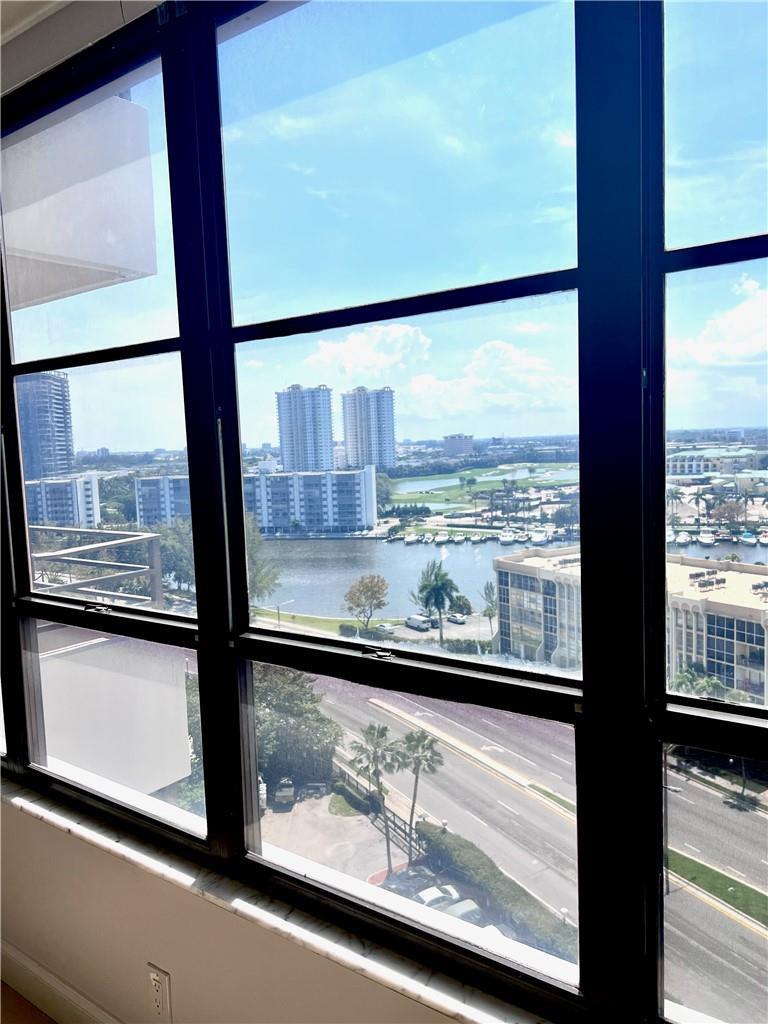 A view of a waterfront city skyline through large, black-framed windows in a room — 600 Three Islands Boulevard # 1108, Hallandale Beach FL 33009, HALLANDALE BEACH, FL