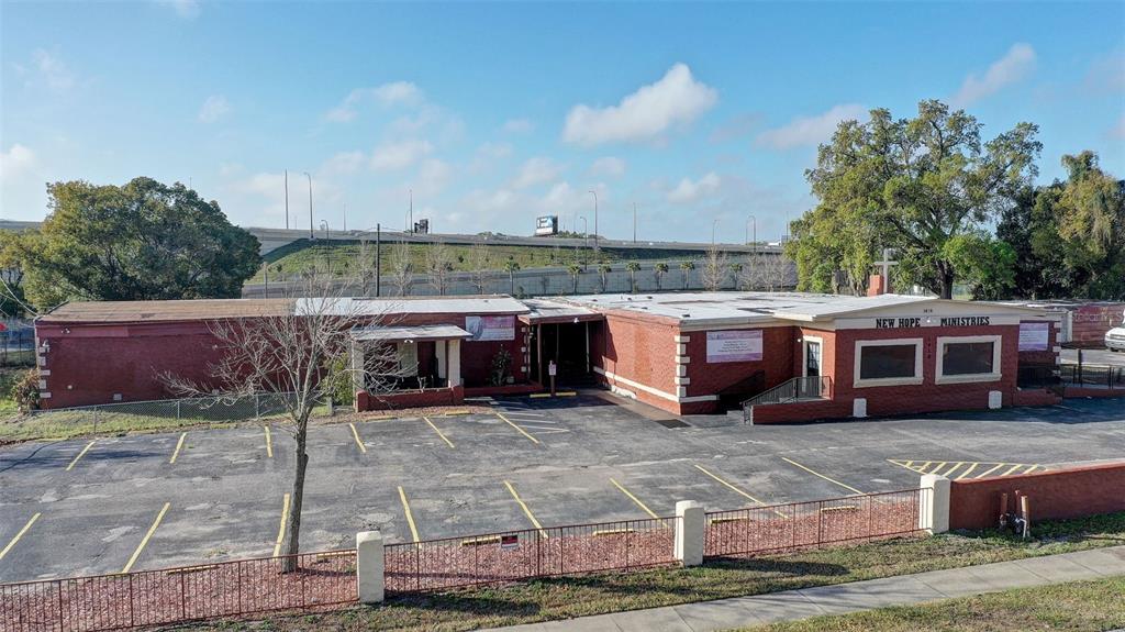 An exterior view of a single-story brick building labeled New Hope Ministries with a parking lot — 1416 30TH ST, ORLANDO, FL
