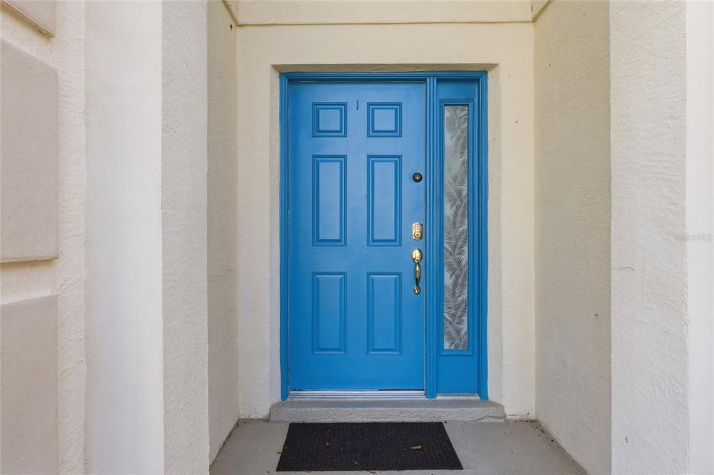 A bright blue front door with a side window sits in a recessed entryway — 816 TROON CIRCLE, DAVENPORT, FL
