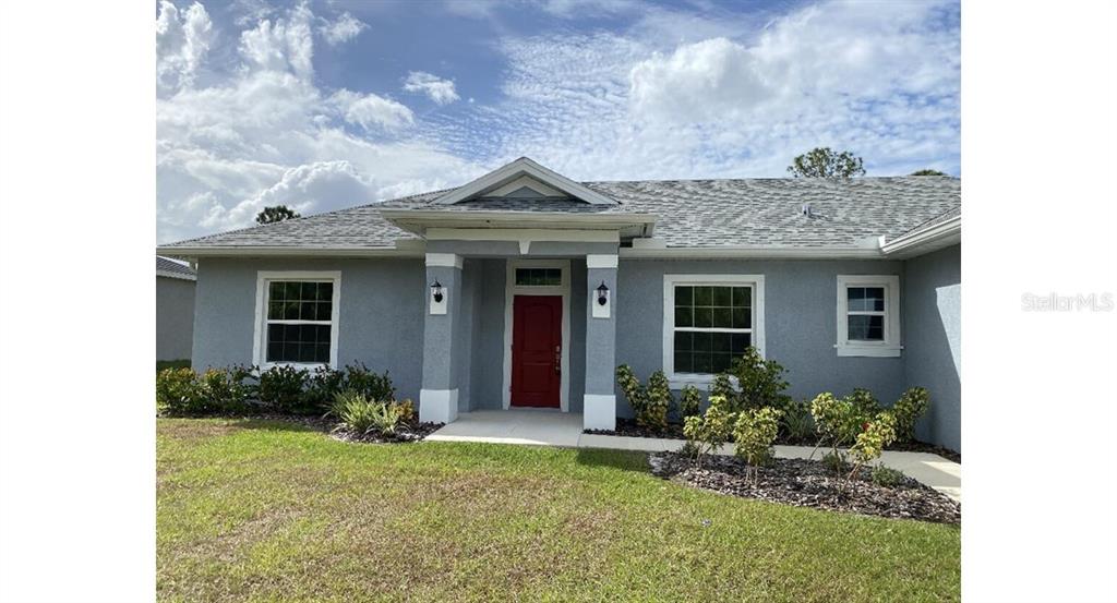 A gray single-story house with a red front door and a covered entryway — 5637 ABELMAN ROAD, NORTH PORT, FL