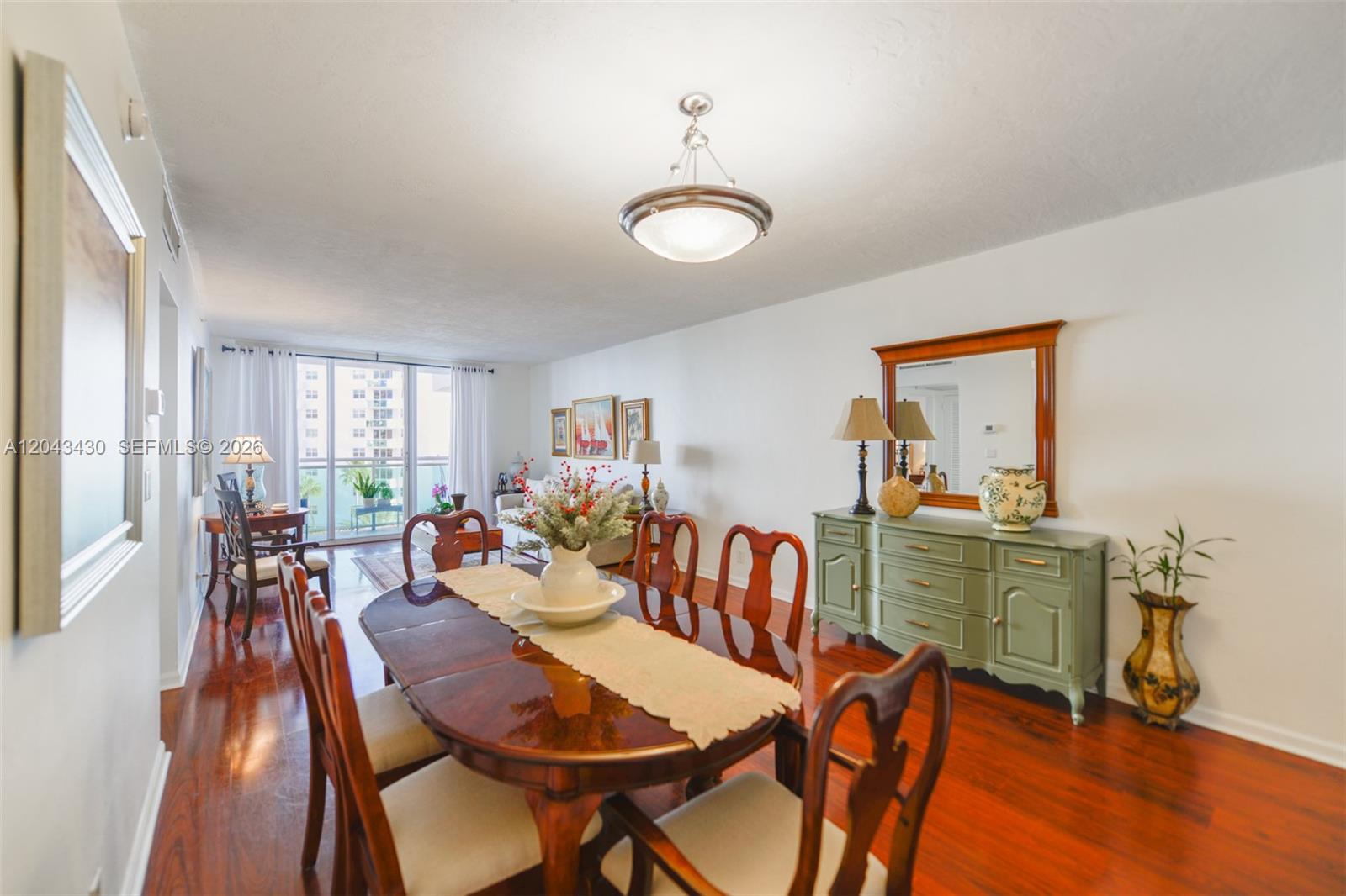 A dining room features a wooden table, chairs, and a green sideboard with a mirror — 3000 S Ocean Dr # 514, Hollywood FL 33019, HOLLYWOOD, FL