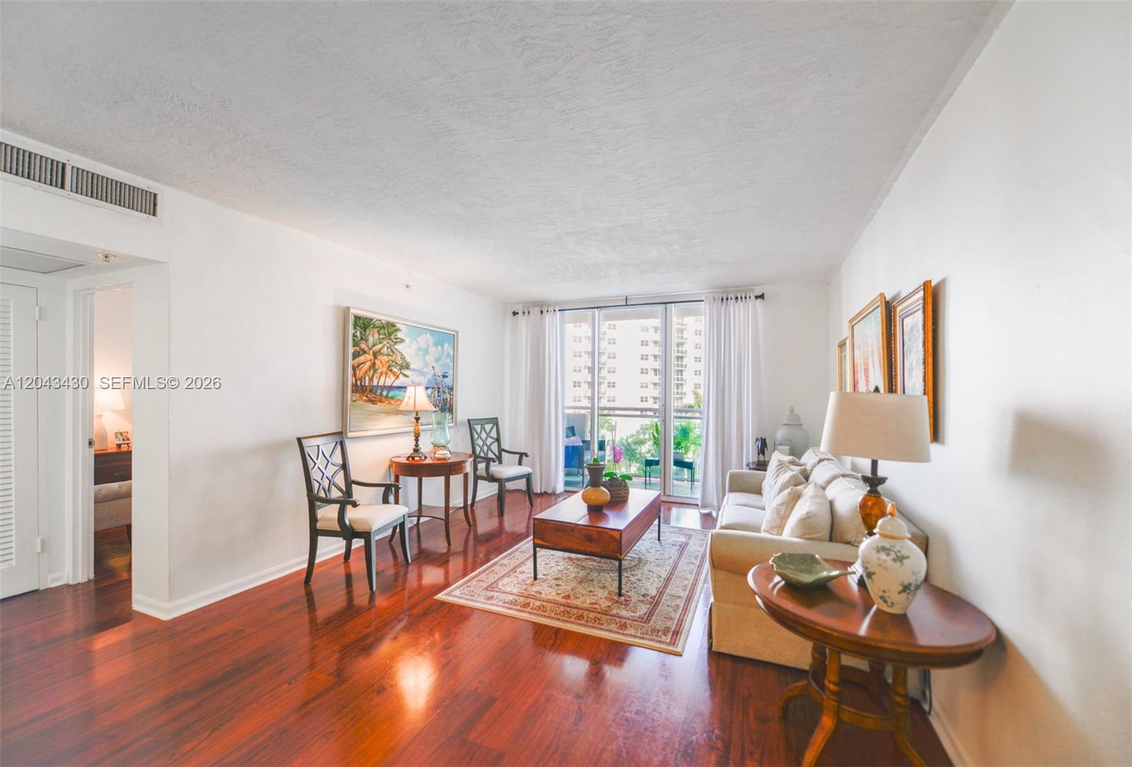 A living room features hardwood floors, a beige sofa, two accent chairs, and a balcony — 3000 S Ocean Dr # 514, Hollywood FL 33019, HOLLYWOOD, FL