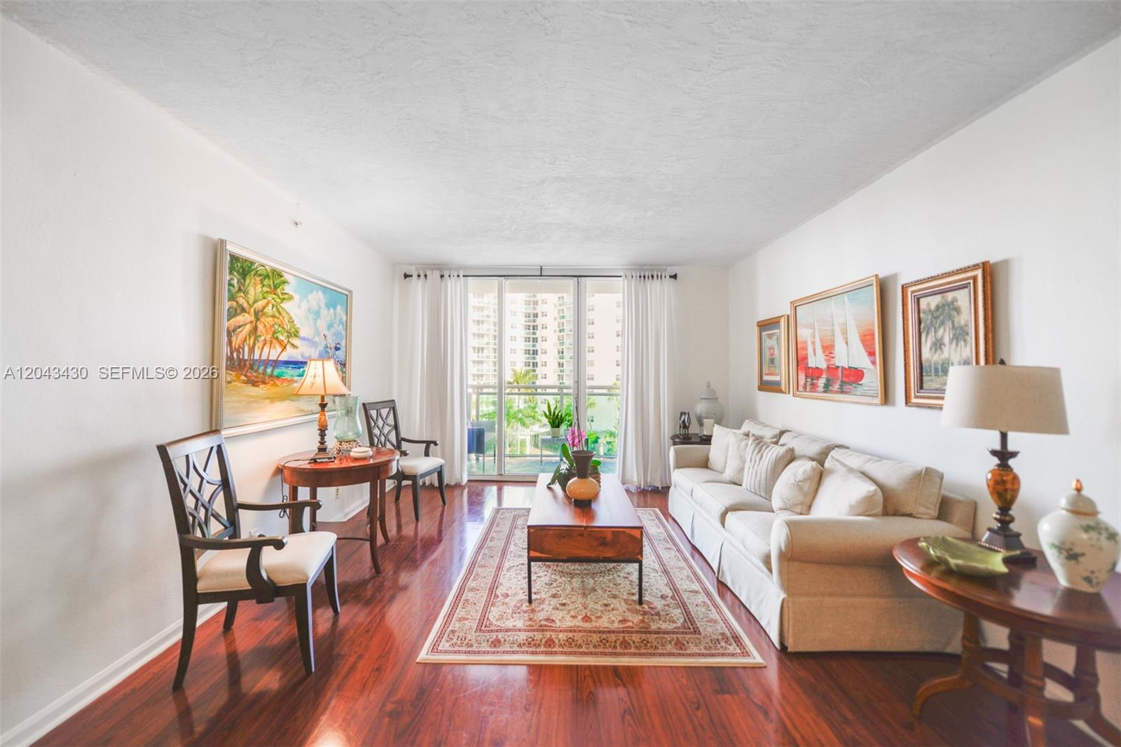 A living room features hardwood floors, a beige sofa, a coffee table, and wall art — 3000 S Ocean Dr # 514, Hollywood FL 33019, HOLLYWOOD, FL