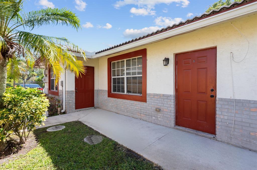 The exterior of a single-story building features two red doors, a window, and brick siding — 617 NW 15th Avenue, Pompano Beach FL 33069, POMPANO BEACH, FL