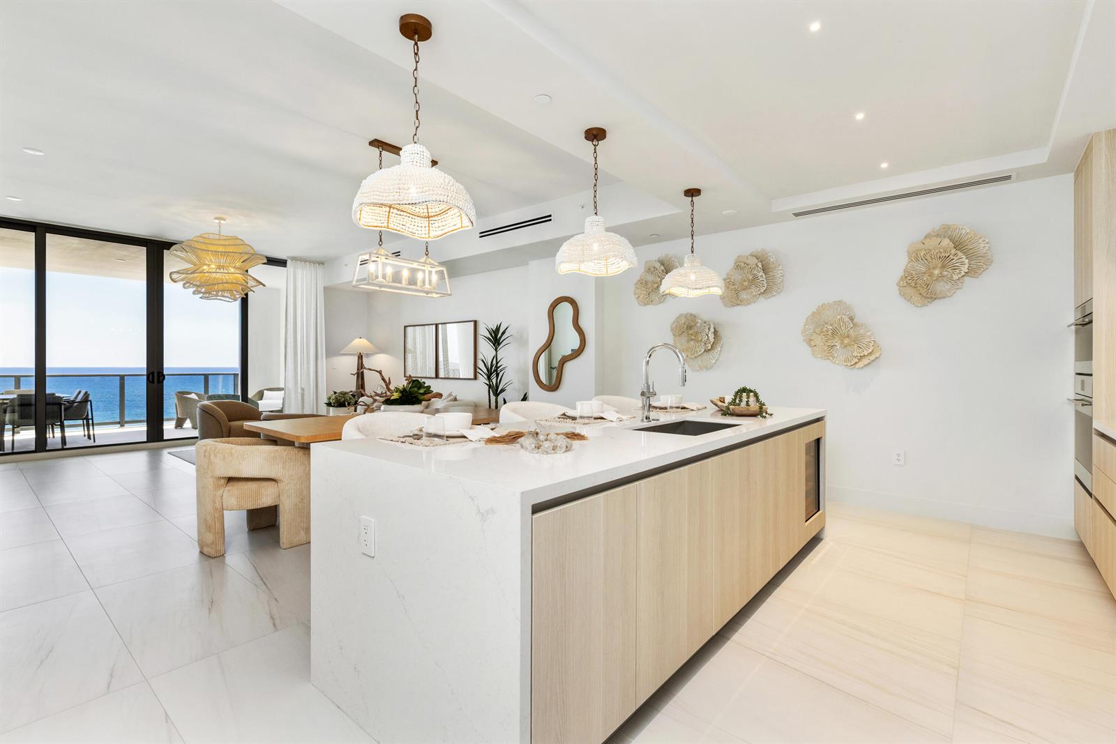 A modern kitchen features a large white quartz island, light wood cabinetry, and ocean views — 305 Briny Avenue # 804, Pompano Beach FL 33062, POMPANO BEACH, FL