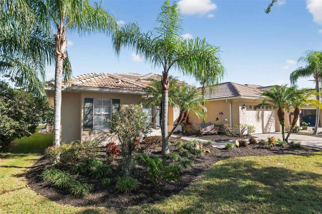 A single-story house with a tile roof, palm trees, and a landscaped front yard — 3816 EAGLE ISLE CIRCLE, KISSIMMEE, FL