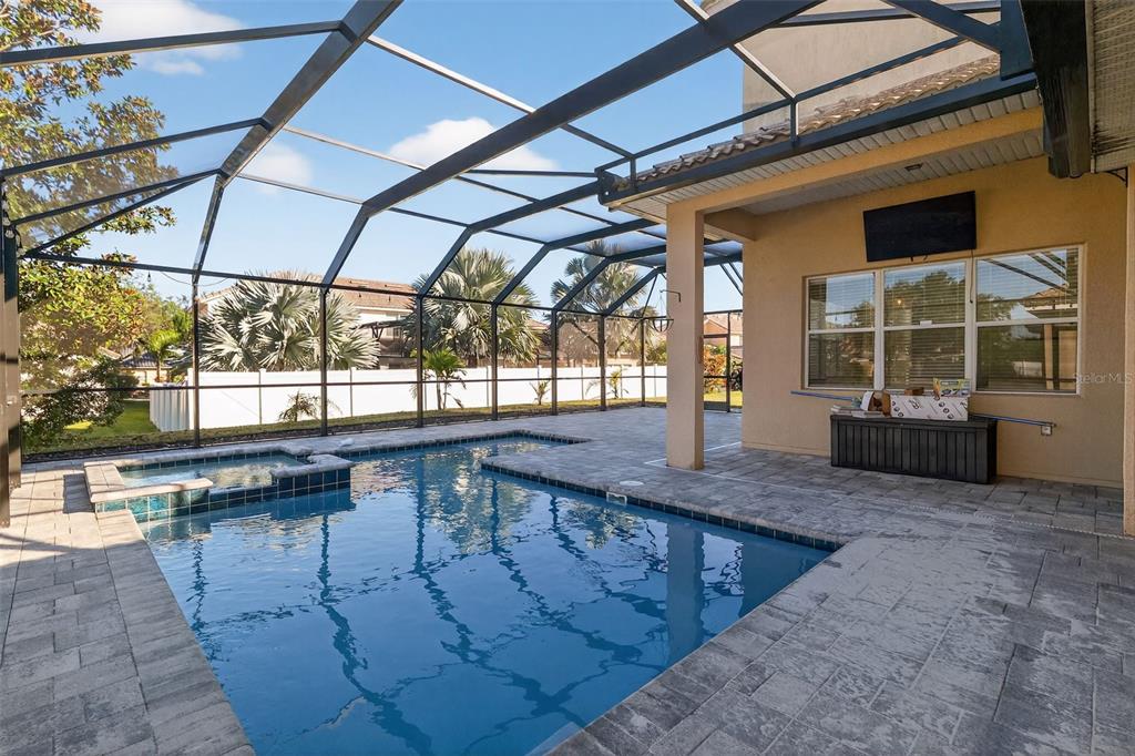 A screened-in patio features a swimming pool, a hot tub, and beige exterior walls — 3816 EAGLE ISLE CIRCLE, KISSIMMEE, FL