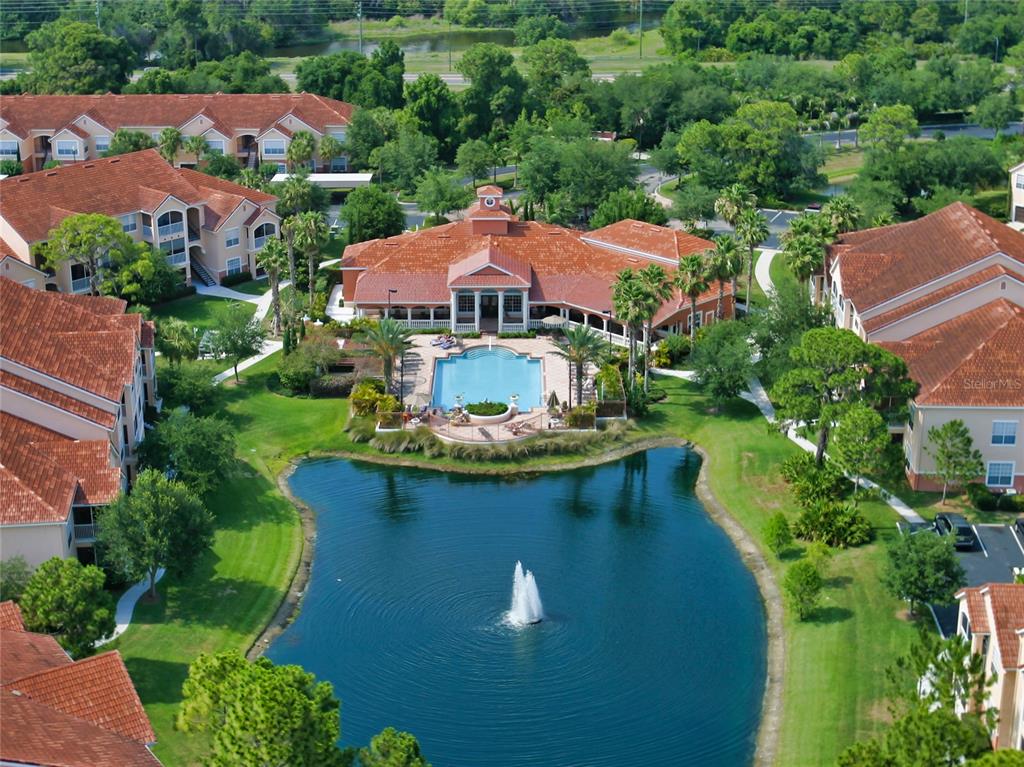 An aerial view shows a community clubhouse with a pool overlooking a fountain-filled pond — 4118 CENTRAL SARASOTA PARKWAY UNIT 1628, SARASOTA, FL