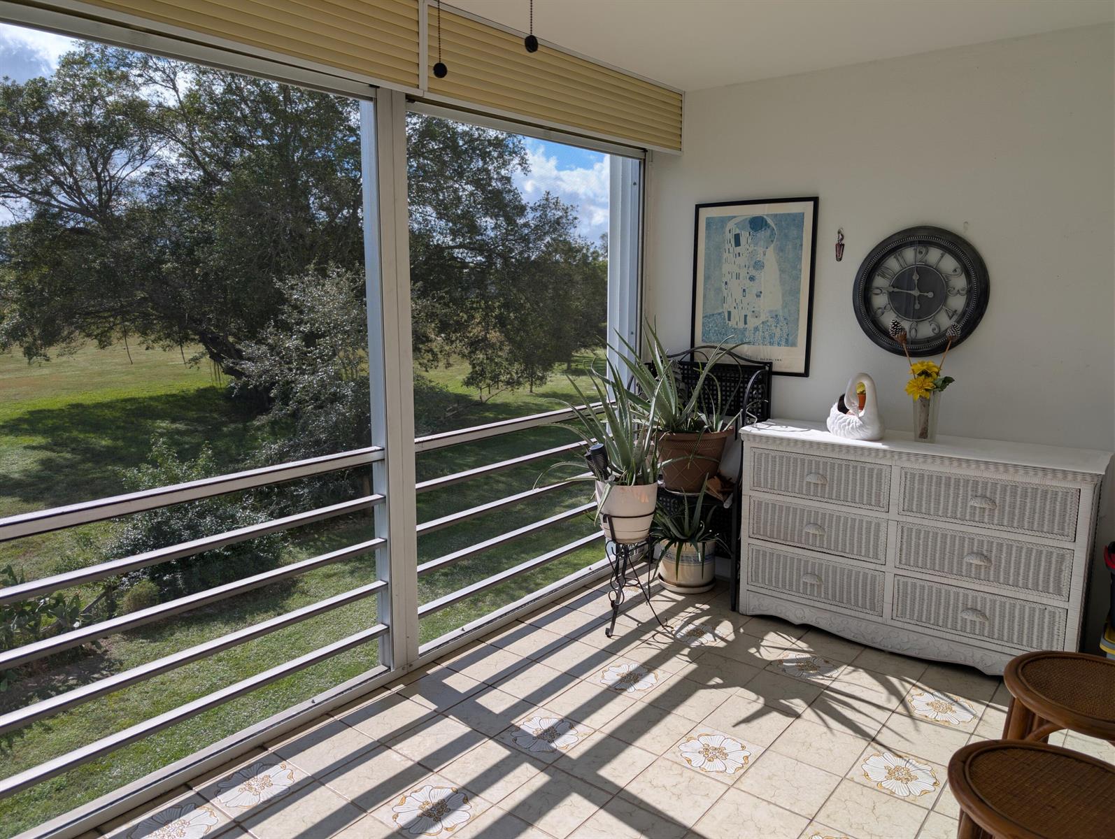 A sunroom with tiled floors, a white wicker dresser, and large windows overlooking a yard — 3036 Ventnor H # 3036, Deerfield Beach FL 33442, DEERFIELD BEACH, FL