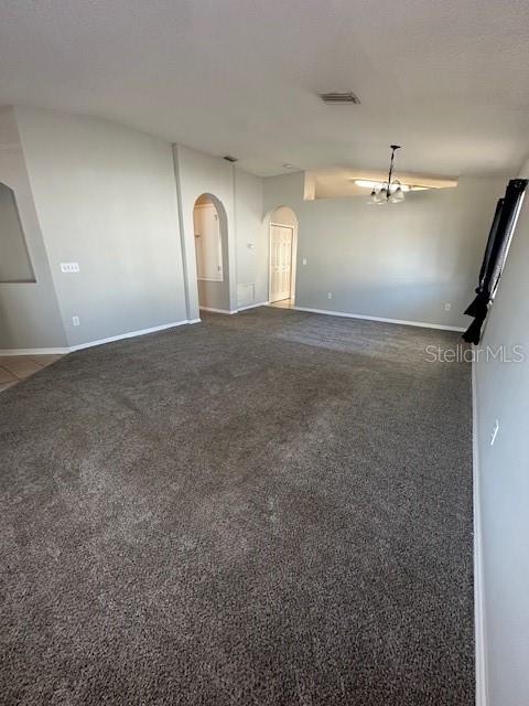 A spacious living room features gray carpeting, neutral walls, and an arched doorway — 11121 KEMPTON VISTA DRIVE, RIVERVIEW, FL