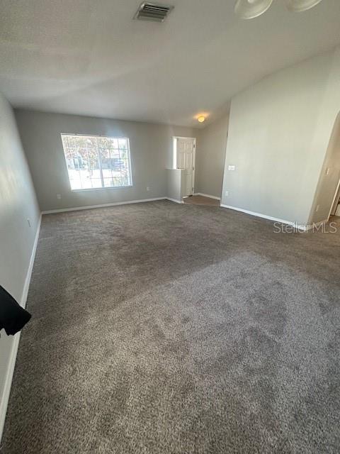 A spacious, carpeted living room features a large window and a doorway leading to another room — 11121 KEMPTON VISTA DRIVE, RIVERVIEW, FL