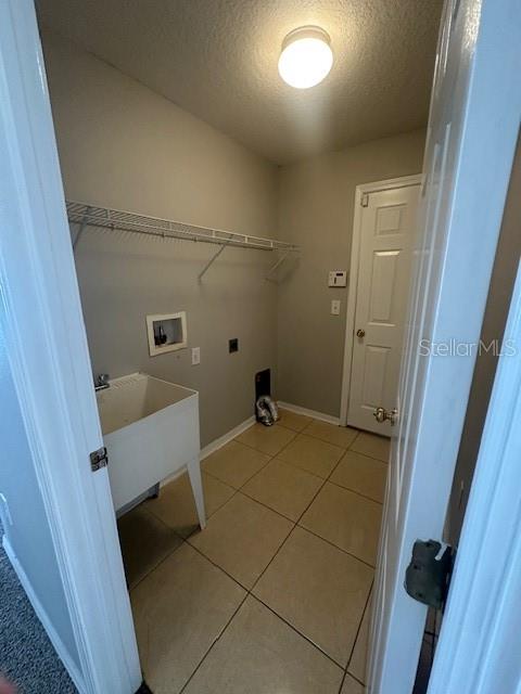 This laundry room features a utility sink, wire shelving, and light-colored tile flooring — 11121 KEMPTON VISTA DRIVE, RIVERVIEW, FL