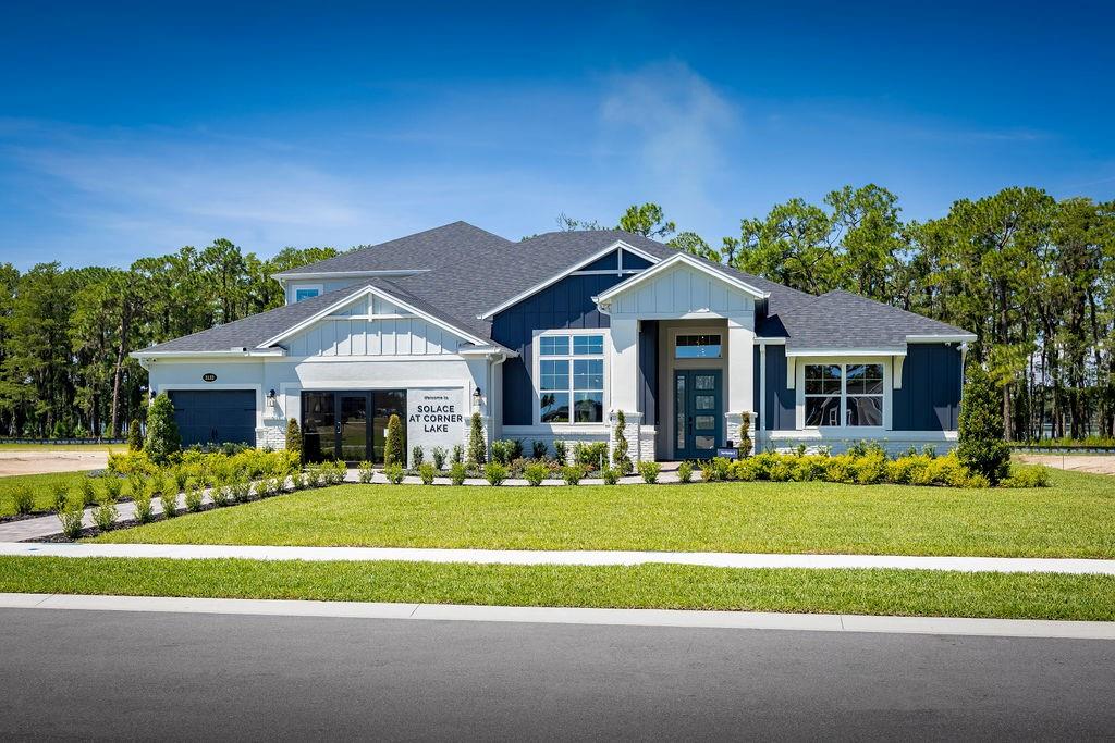 A single-story house with blue siding, white trim, and a front-facing garage under a blue sky — 3132 SOLACE WAY, ORLANDO, FL
