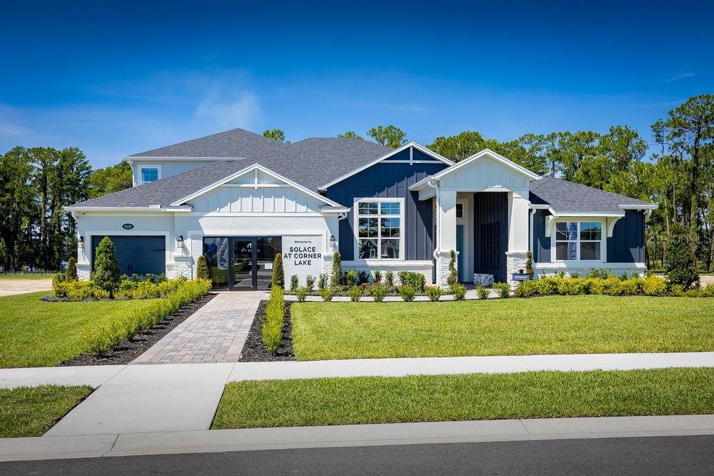 A modern single-story house with a white brick facade, dark blue siding, and a paved walkway — 3132 SOLACE WAY, ORLANDO, FL
