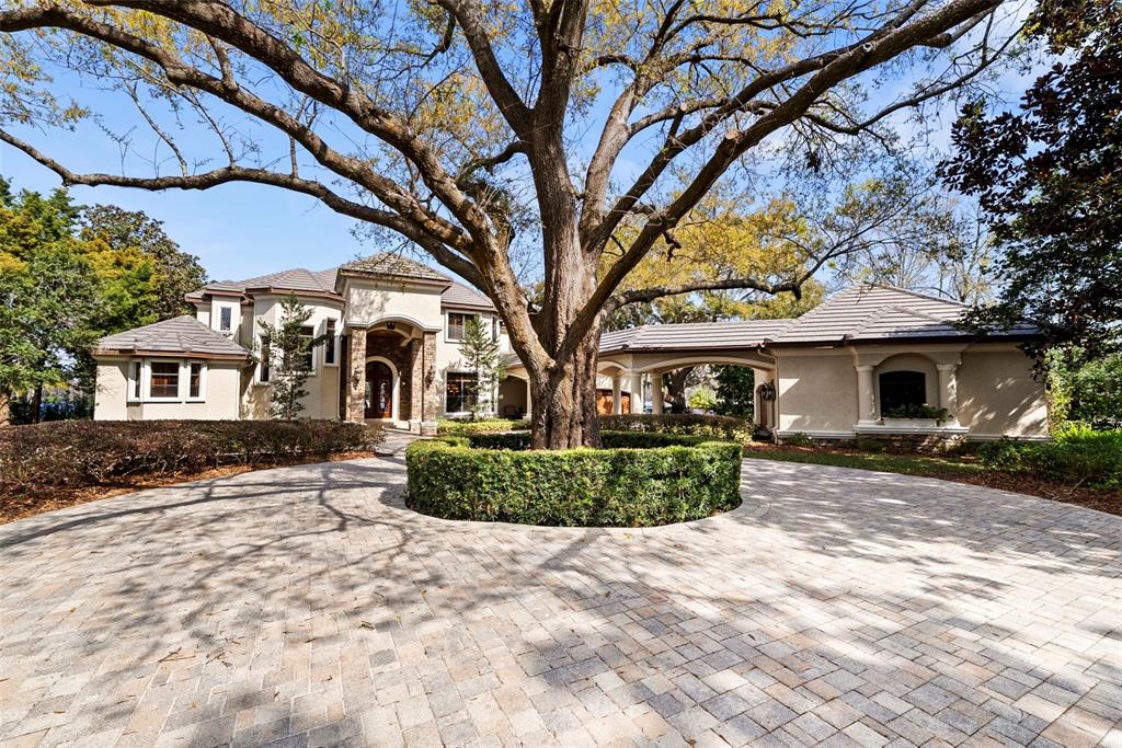 A large house with a pool, stone hot tub, and covered patio at sunset — 9902 MENANDER WOOD COURT, ODESSA, FL