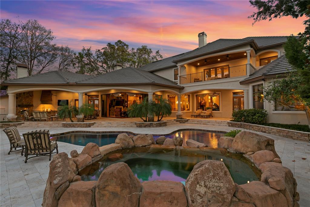 A large two-story house features a circular paver driveway with a central tree and hedge — 9902 MENANDER WOOD COURT, ODESSA, FL