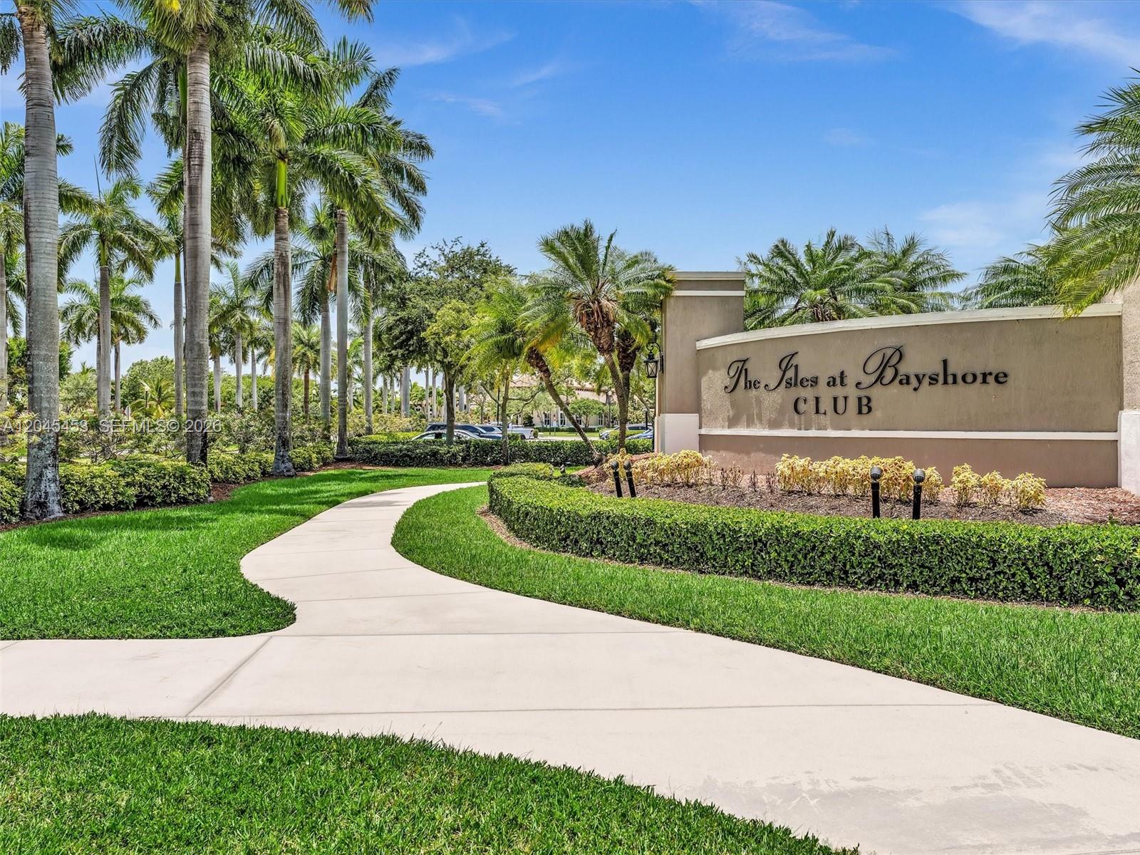 A curved concrete walkway leads to a sign for The Isles at Bayshore Club — 8887 SW 225th St, Cutler Bay FL 33190, CUTLER BAY, FL