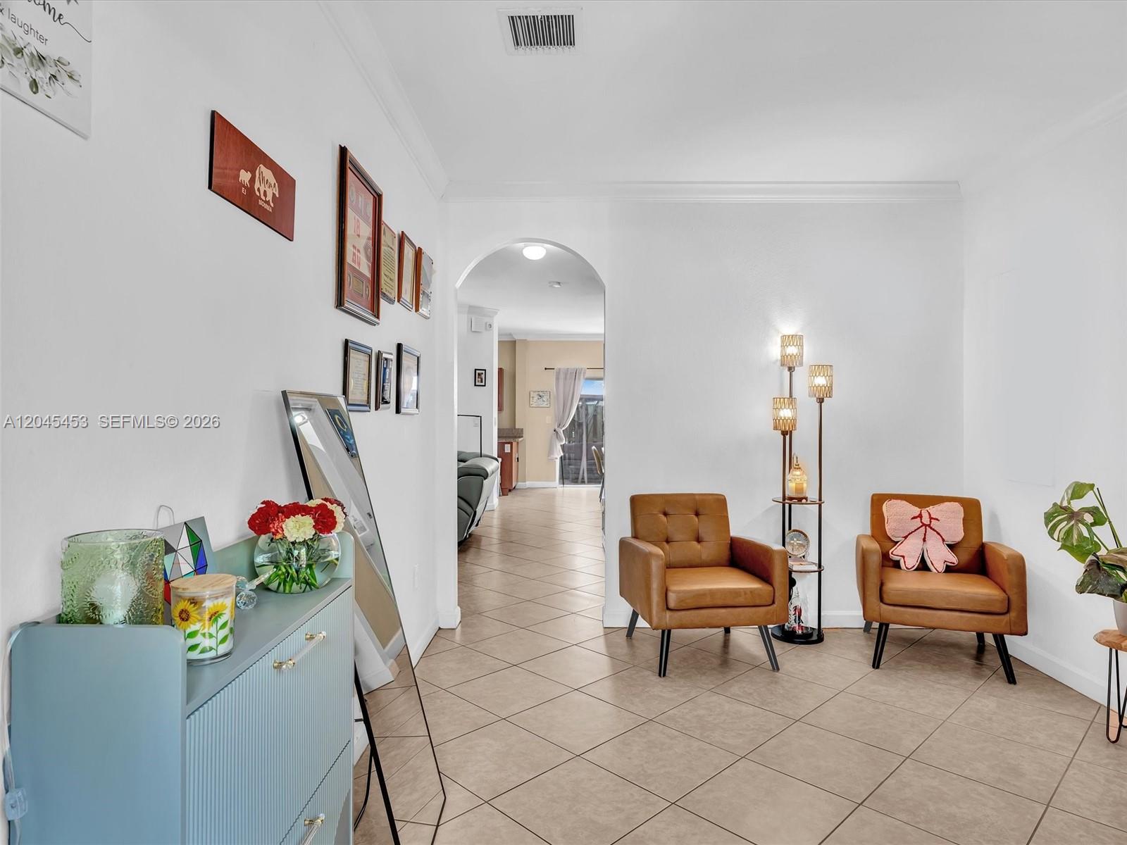 A living area features two brown armchairs, a floor lamp, and a blue cabinet — 8887 SW 225th St, Cutler Bay FL 33190, CUTLER BAY, FL