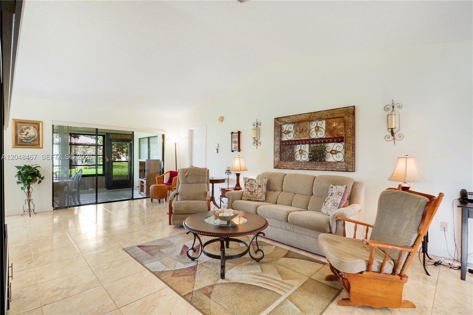 A living room features tile floors, a beige sofa, two armchairs, and a sliding glass door — 3449 Shadow Wood Dr, Green Acres FL 33463, GREEN ACRES, FL