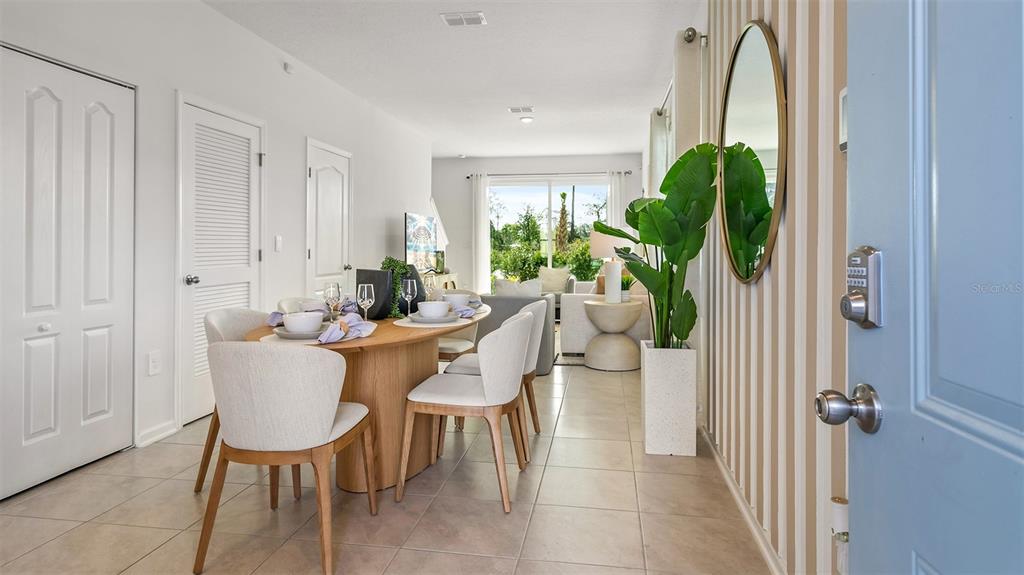 An open-concept dining and living area features tile flooring, striped wallpaper, and a round table — 296 PALMETTO RIDGE ROAD, ST AUGUSTINE, FL