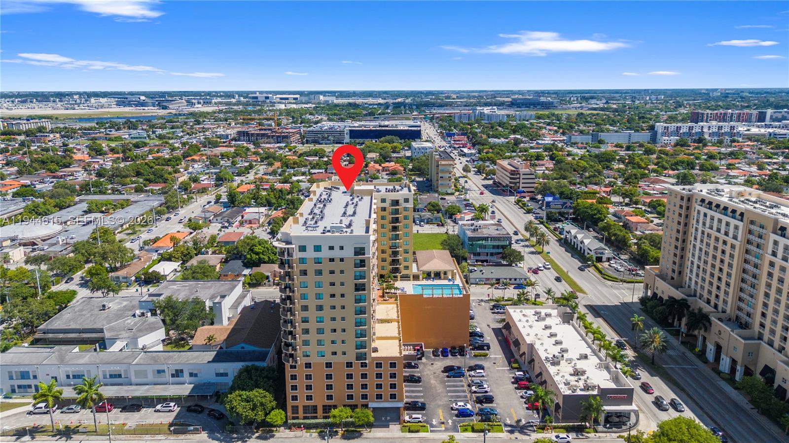 An aerial view shows a tall apartment building with a rooftop pool and parking lot — 4242 NW 2nd St # 1609, Miami FL 33126, MIAMI, FL