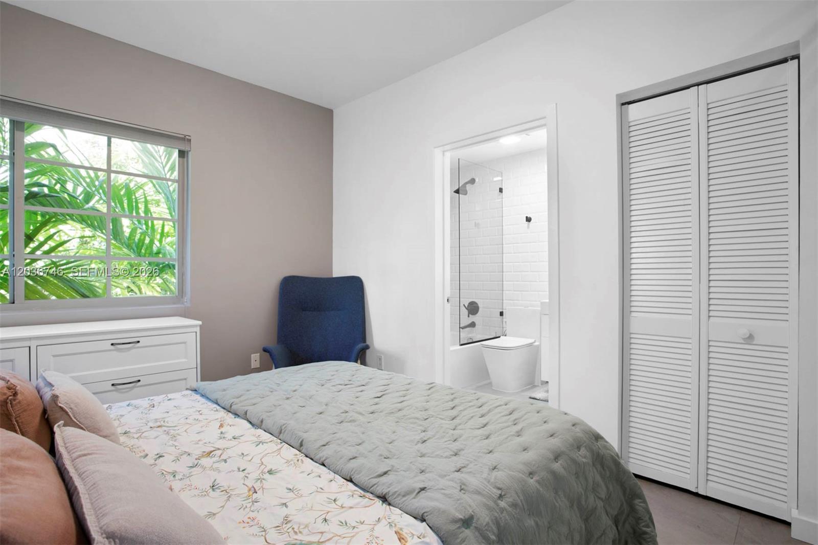 A bedroom features a bed, a blue chair, a white dresser, and an attached bathroom — 901 3rd St # 3, Miami Beach FL 33139, MIAMI BEACH, FL