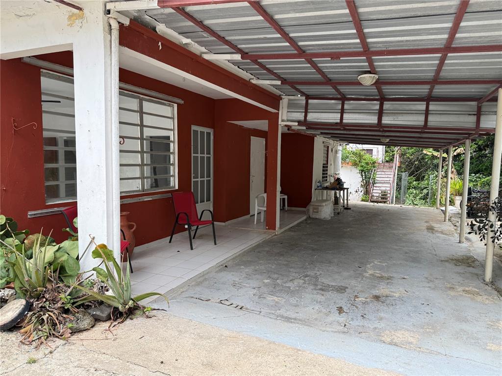 A red house exterior features a covered concrete carport and a tiled front porch area — Carr. 901 CAMINO NUEVO, YABUCOA, PR