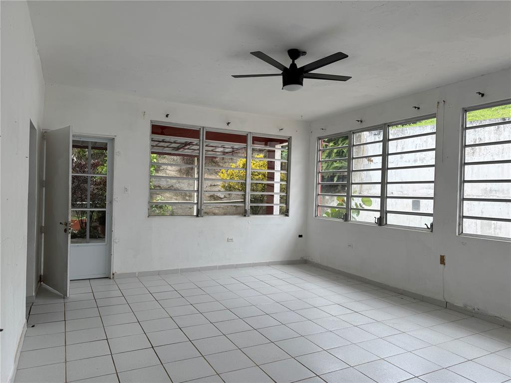 An empty room features white walls, white tile flooring, a ceiling fan, and louvered windows — Carr. 901 CAMINO NUEVO, YABUCOA, PR