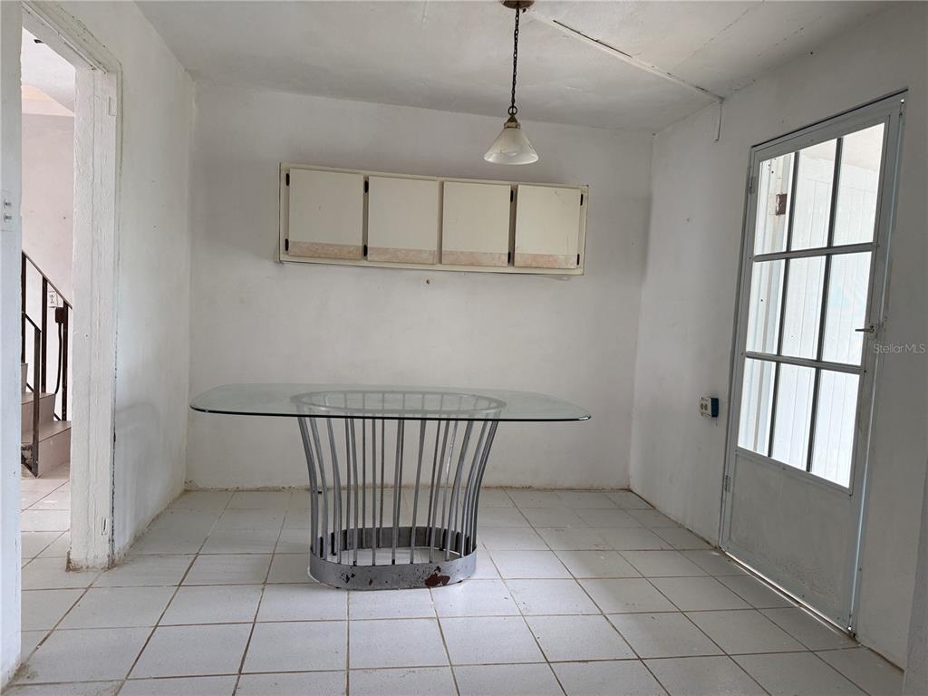 A dining area features white tile floors, a glass-topped table, and wall-mounted cabinets — Carr. 901 CAMINO NUEVO, YABUCOA, PR