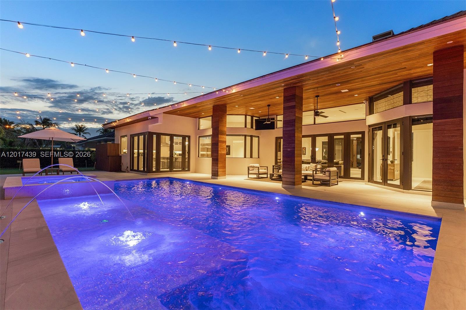 A modern house exterior features a swimming pool with fountains and a covered patio area — 10040 SW 124th St, Miami FL 33176, MIAMI, FL