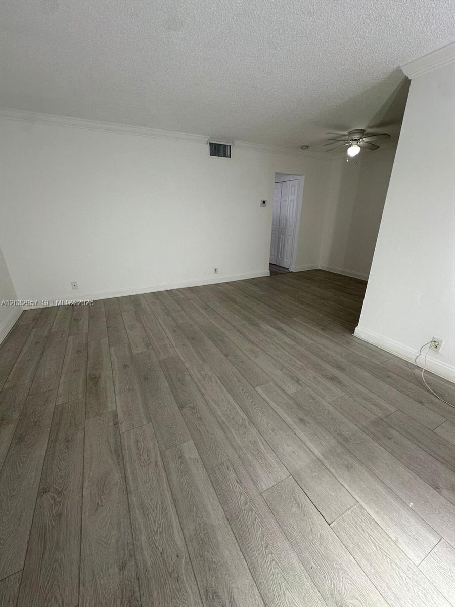 An empty room features light wood-look flooring, white walls, and a ceiling fan — 2008 N Jackson St # B4, Hollywood FL 33020, HOLLYWOOD, FL