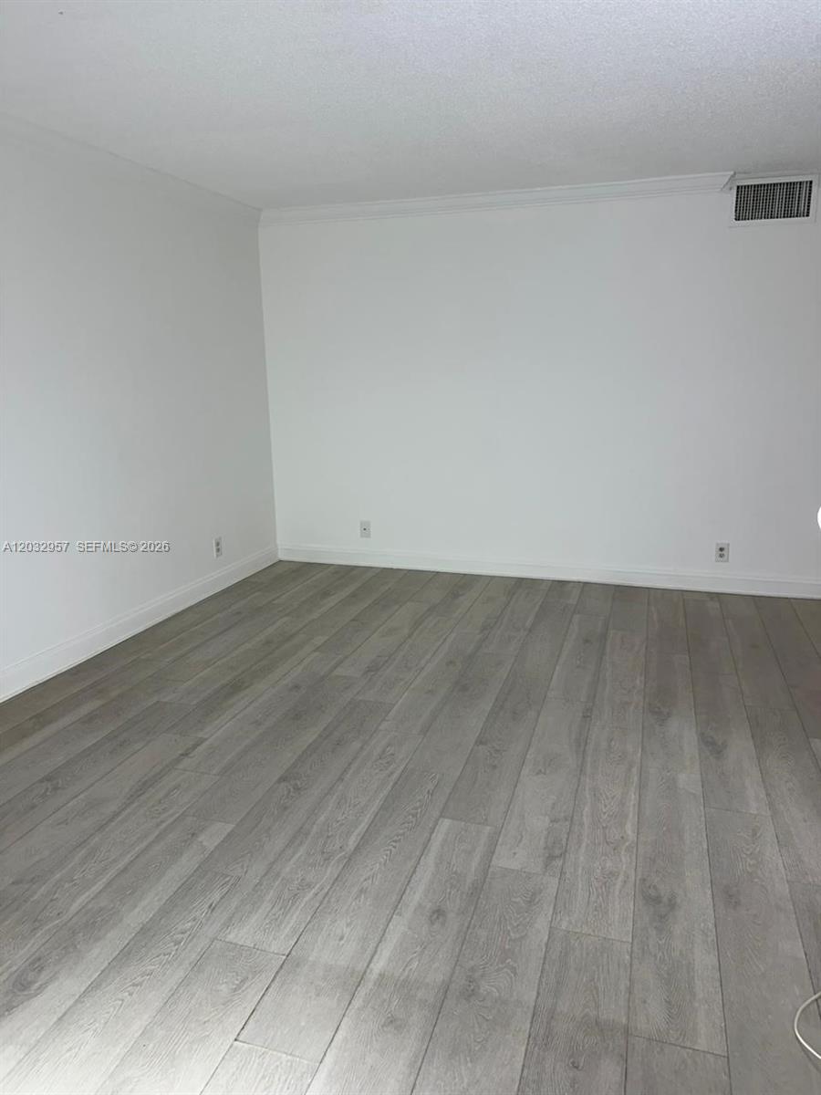 An empty room features white walls, baseboards, and light-colored wood-look flooring — 2008 N Jackson St # B4, Hollywood FL 33020, HOLLYWOOD, FL