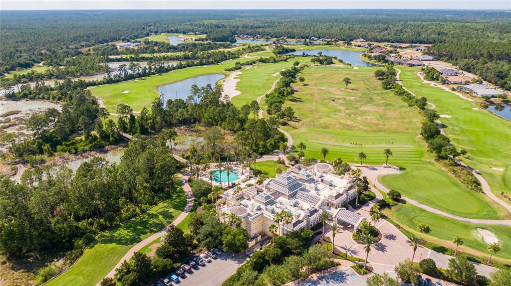An aerial view shows a large clubhouse with a pool surrounded by a golf course — 803 LOBLOLLY COURT, PALM COAST, FL