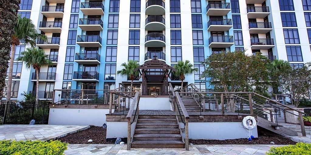 A multi-story apartment building features balconies and a wooden staircase leading to a central entrance — 55-1 W CHURCH STREET, ORLANDO, FL