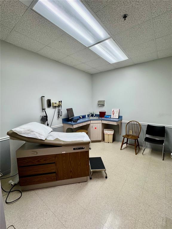 A medical examination room features a treatment table, a desk, and two chairs — 2401 FRIST BOULEVARD UNIT #1-2, FORT PIERCE, FL