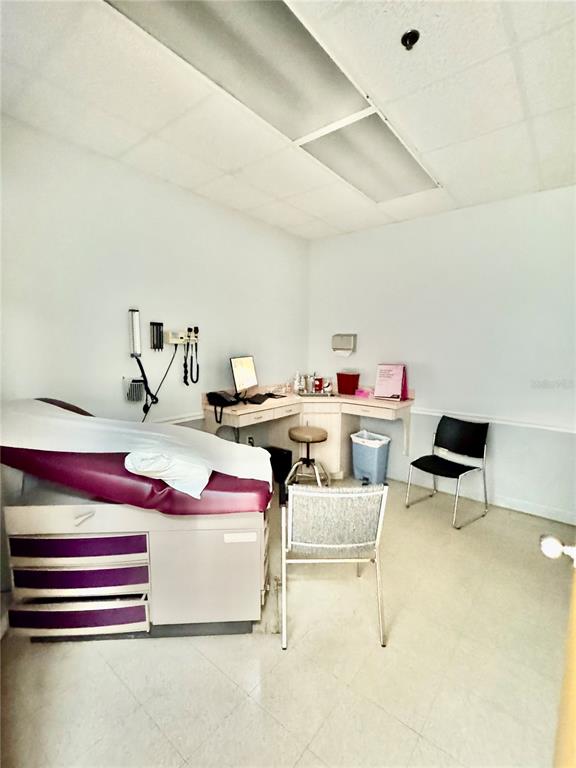 A medical examination room features a treatment table, a desk with a computer, and chairs — 2401 FRIST BOULEVARD UNIT #1-2, FORT PIERCE, FL