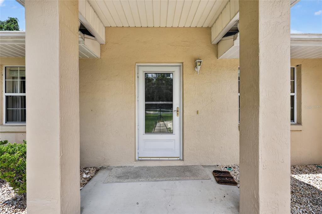 The exterior view shows a concrete driveway leading to a garage with a screen door — 16200 SE 91ST COURT, SUMMERFIELD, FL