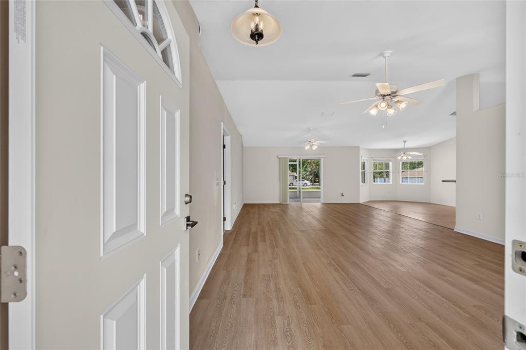 A covered entryway features a white front door with a glass panel and concrete flooring — 16200 SE 91ST COURT, SUMMERFIELD, FL