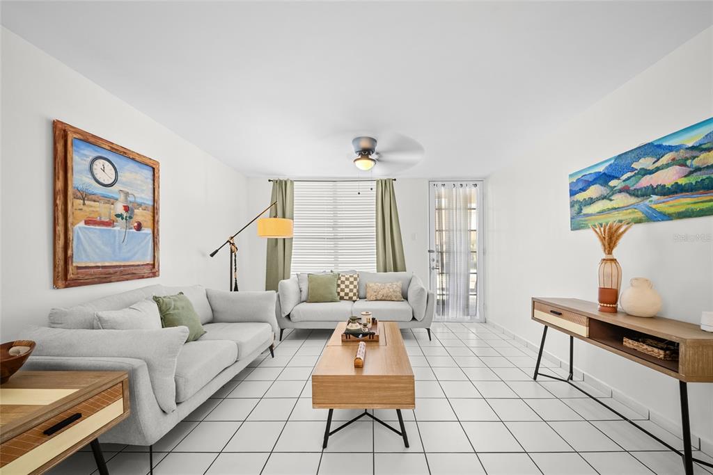 A living room features two light gray sofas, a wood coffee table, and white tile floors — N13 CALLE BORIKEN URB. ALTURAS DEL ENCANTO, JUANA DIAZ, PR