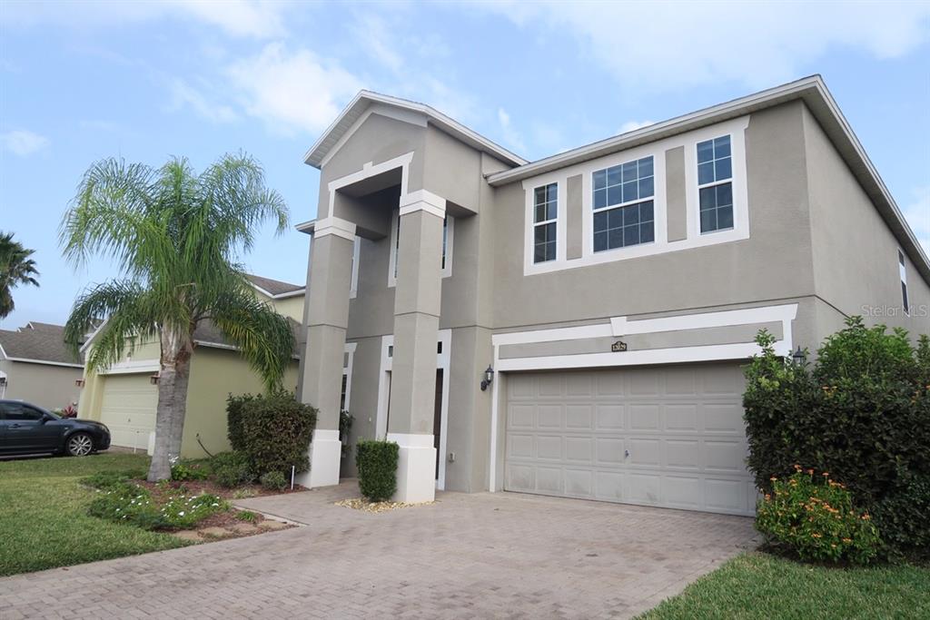 A two-story house with a gray stucco exterior, a two-car garage, and a palm tree — 12029 CITRUSWOOD DRIVE, ORLANDO, FL