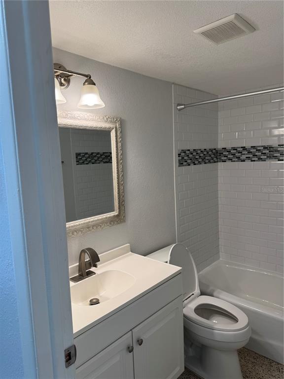 A bathroom features a white vanity, a framed mirror, and a tiled shower-tub combination — 4200 1ST STREET UNIT 2, ST PETERSBURG, FL