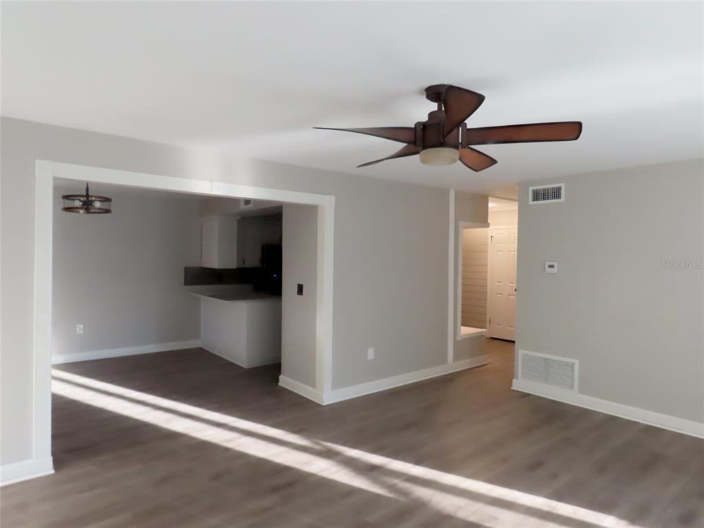 A living room with light gray walls, wood-look flooring, and a ceiling fan — 1798 FAULDS ROAD N, CLEARWATER, FL