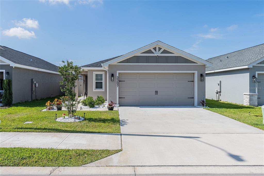An aerial view shows a community swimming pool with lounge chairs and a clubhouse building — 3307 COSTELLO CIRCLE, WINTER HAVEN, FL