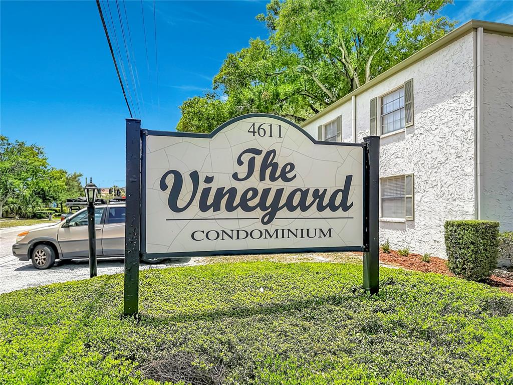 A sign for The Vineyard Condominium stands in front of a white stucco building — 4611 W NORTH B STREET UNIT 240, TAMPA, FL
