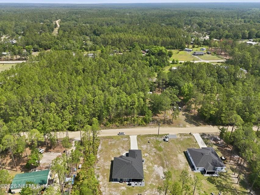 An aerial view shows two houses with dark roofs situated on a large, wooded lot — 490 KAY ROAD, MIDDLEBURG, FL