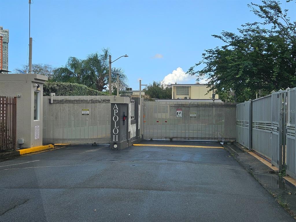 A gated entrance with a metal sliding gate and a sign reading Apollo II — 2085 Hercules st URB ALTO APOLO, GUAYNABO, PR