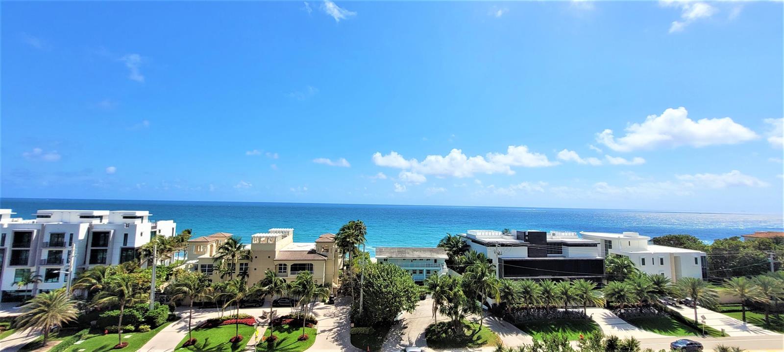 An elevated view of a coastal neighborhood with modern houses, palm trees, and the ocean — 3700 S Ocean Boulevard # 705, Highland Beach FL 33487, HIGHLAND BEACH, FL