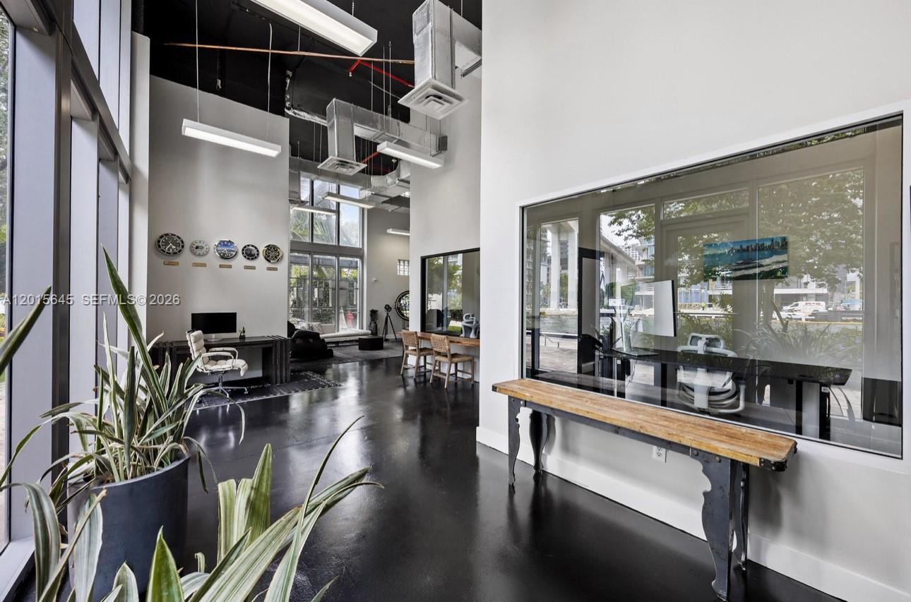 A modern office space features high ceilings, exposed ductwork, black floors, and glass-walled meeting rooms — 92 SW 3rd St, Miami FL 33130, MIAMI, FL