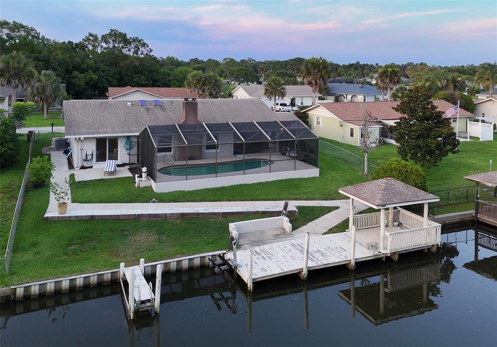 An aerial view of a house with a pool, screened enclosure, and private boat dock — 10 FELICIA COURT, PALM COAST, FL